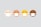Four stylized emoji faces lined up horizontally, each wearing a white mask. The faces have different skin tones ranging from light beige to dark brown. All faces have simple, closed eyes and are set against a plain pale background.