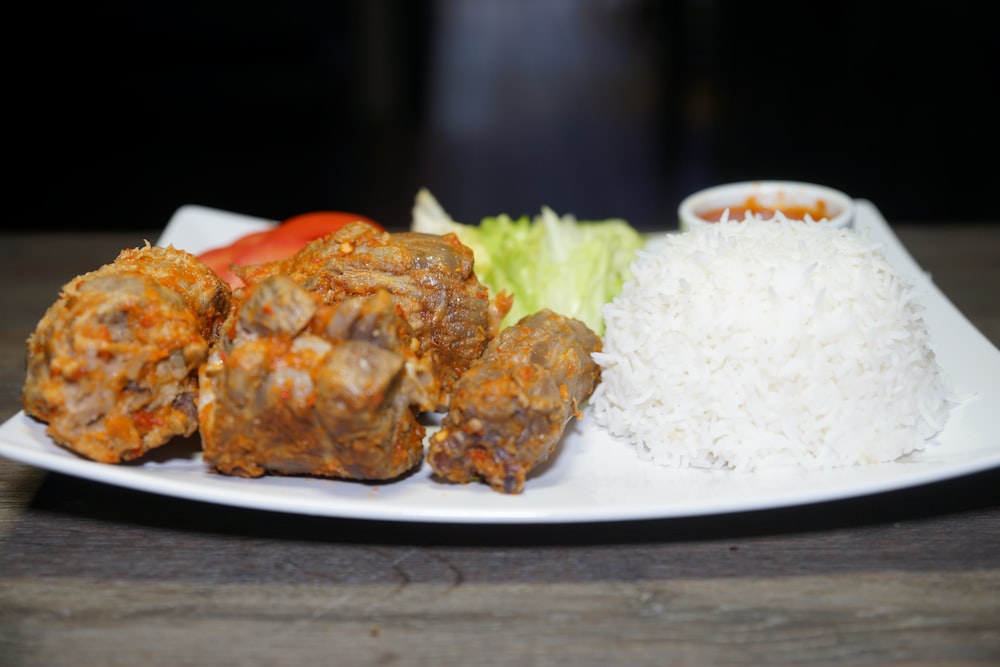 rice and cooked meat on white ceramic plate