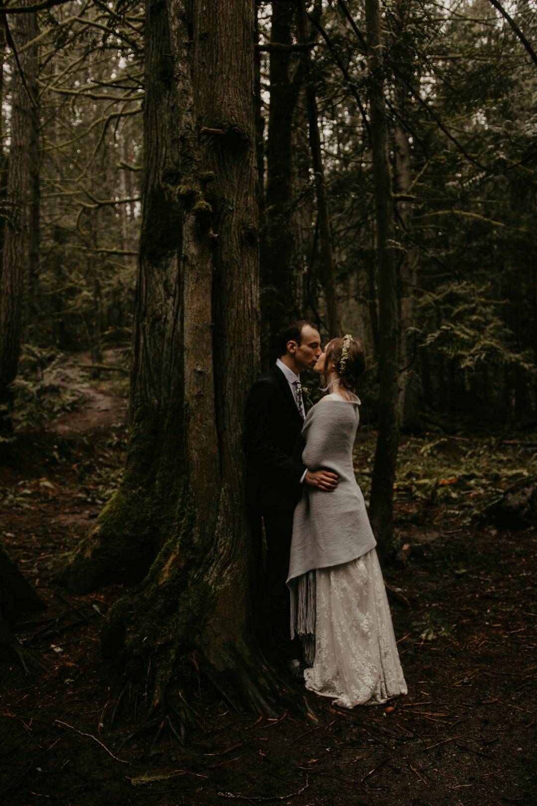 man and woman kissing in forest during daytime