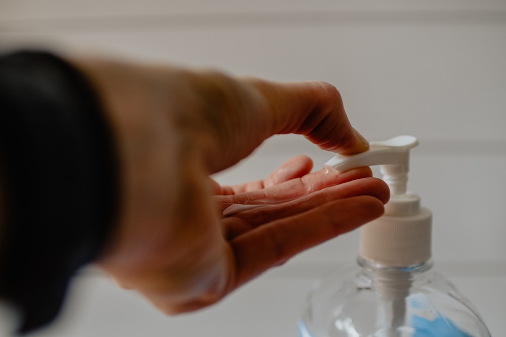 a person's hand reaching for a hand sanitizer