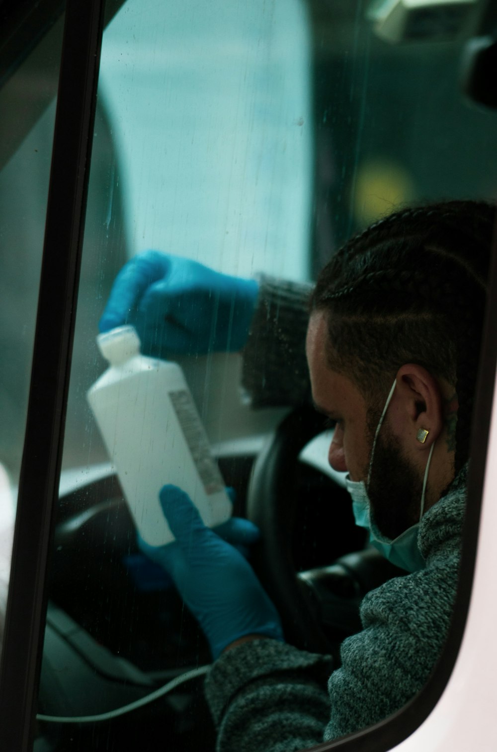 man in blue long sleeve shirt holding white plastic bottle