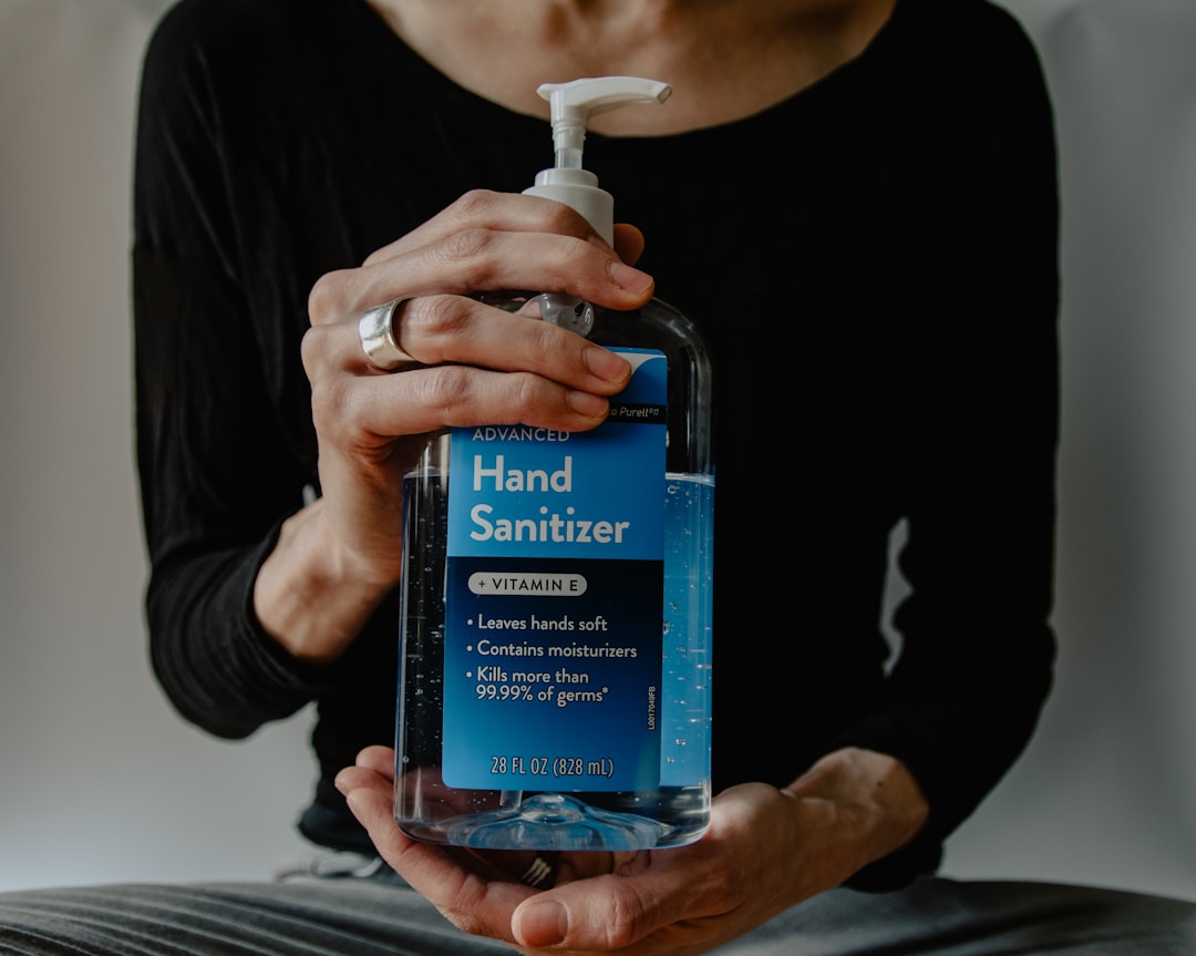 Hands holding a large bottle of hand sanitizer 