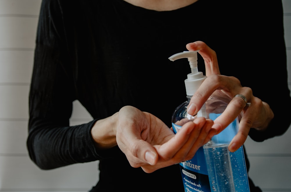 Person mit weißer Plastikpumpflasche