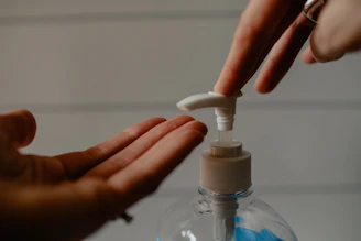 Close-up of a hand pump bottle dispensing clear hand wash foam.