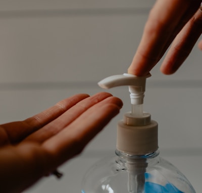 person holding white plastic pump bottle