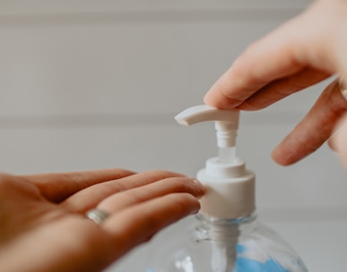 person holding white plastic pump bottle