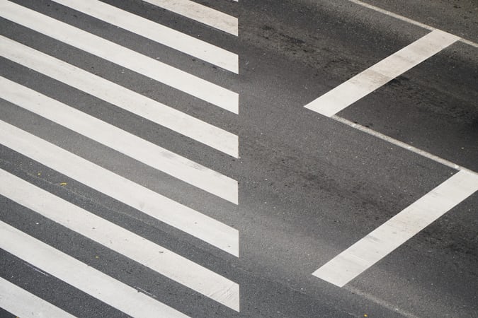 A clearly painted white and black pedestrian crossing on a city street
