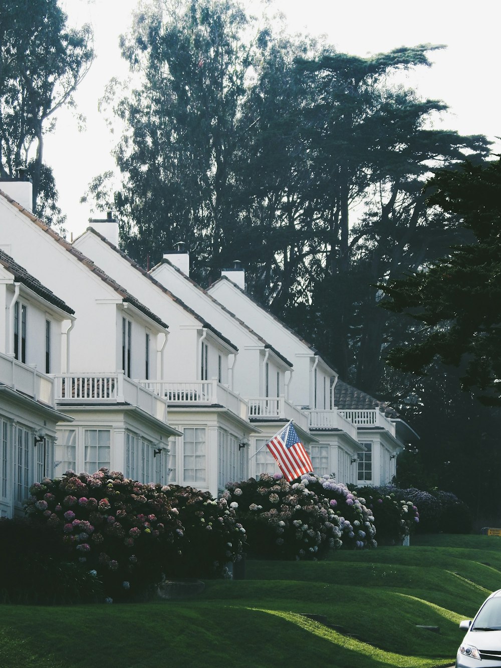 white concrete house near green trees during daytime