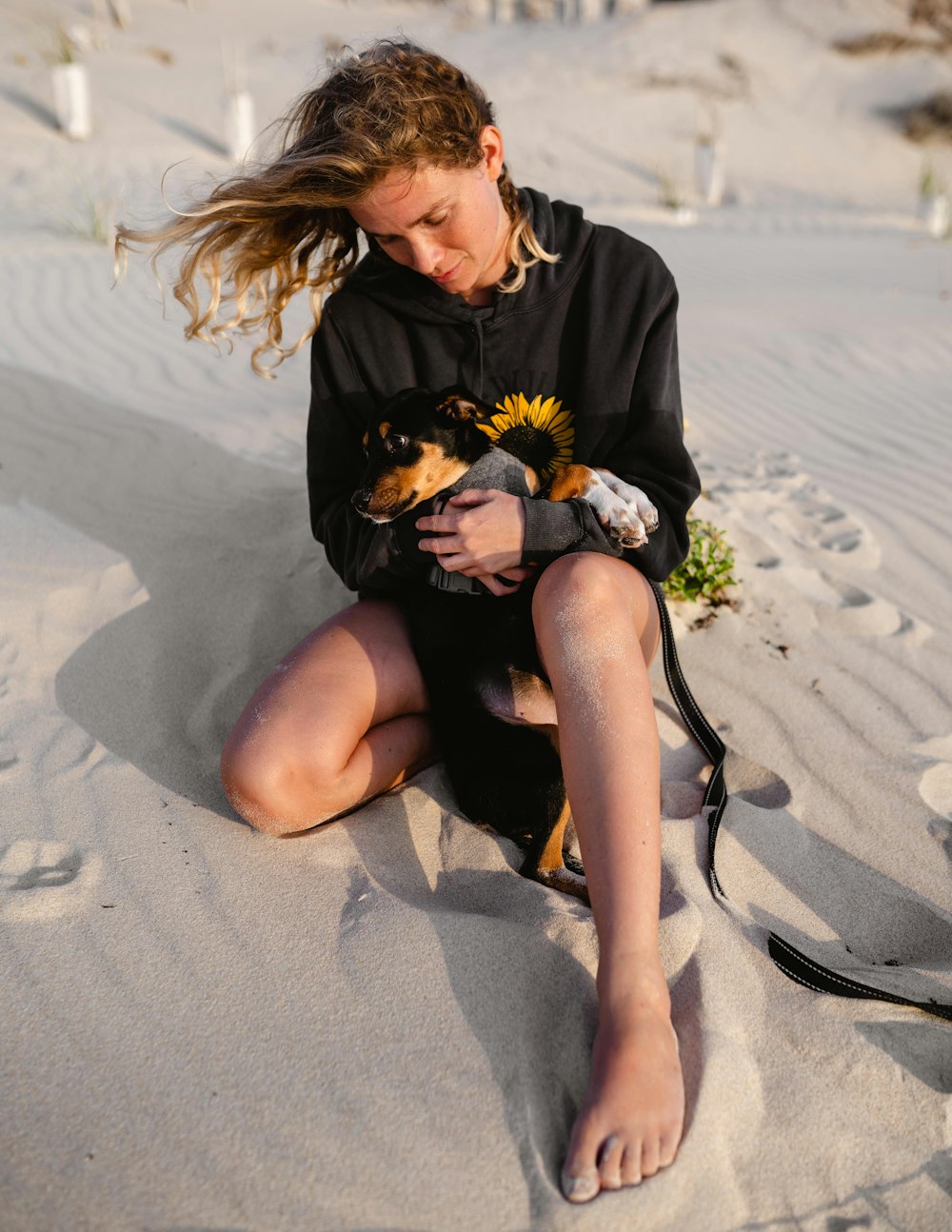 woman in black long sleeve shirt sitting on sand