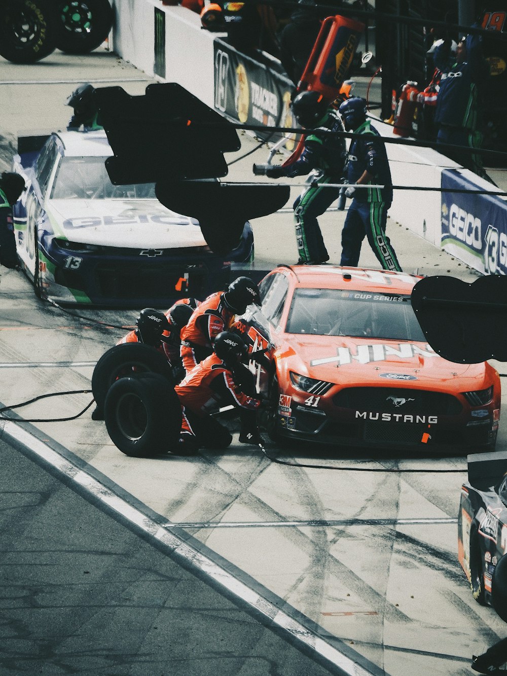 man in black jacket and pants riding orange and black racing car