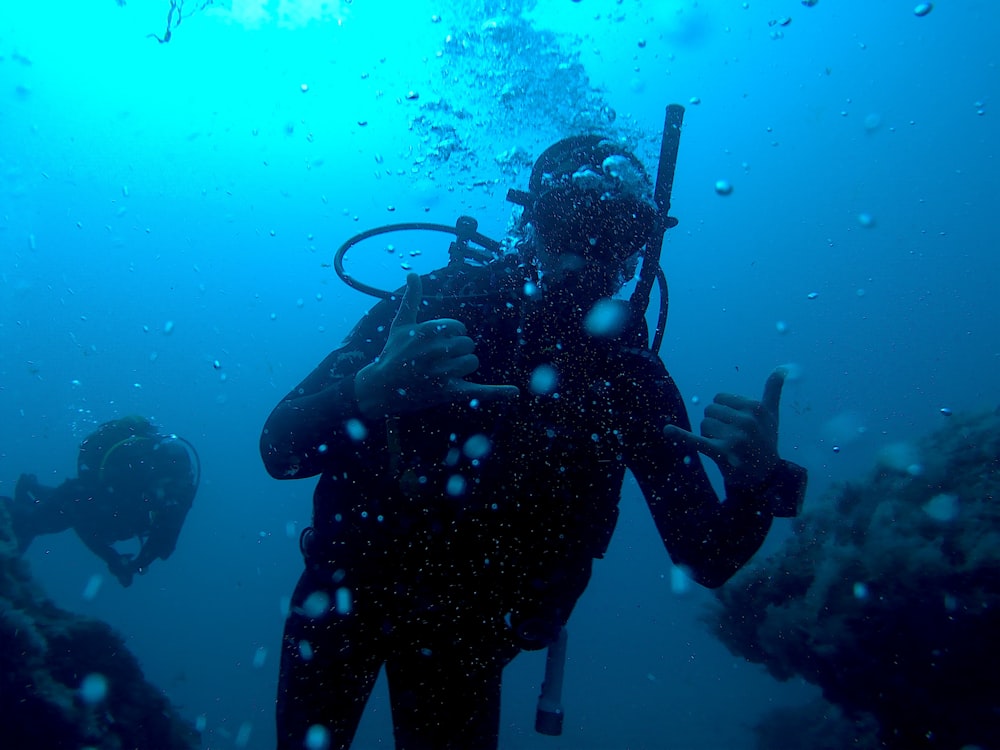 person in black wetsuit under water