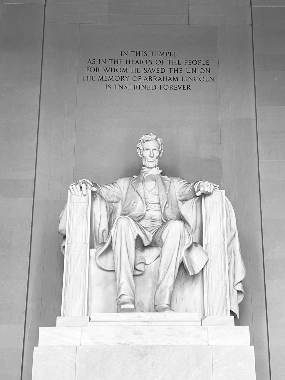 grayscale photo of woman sitting on chair statue