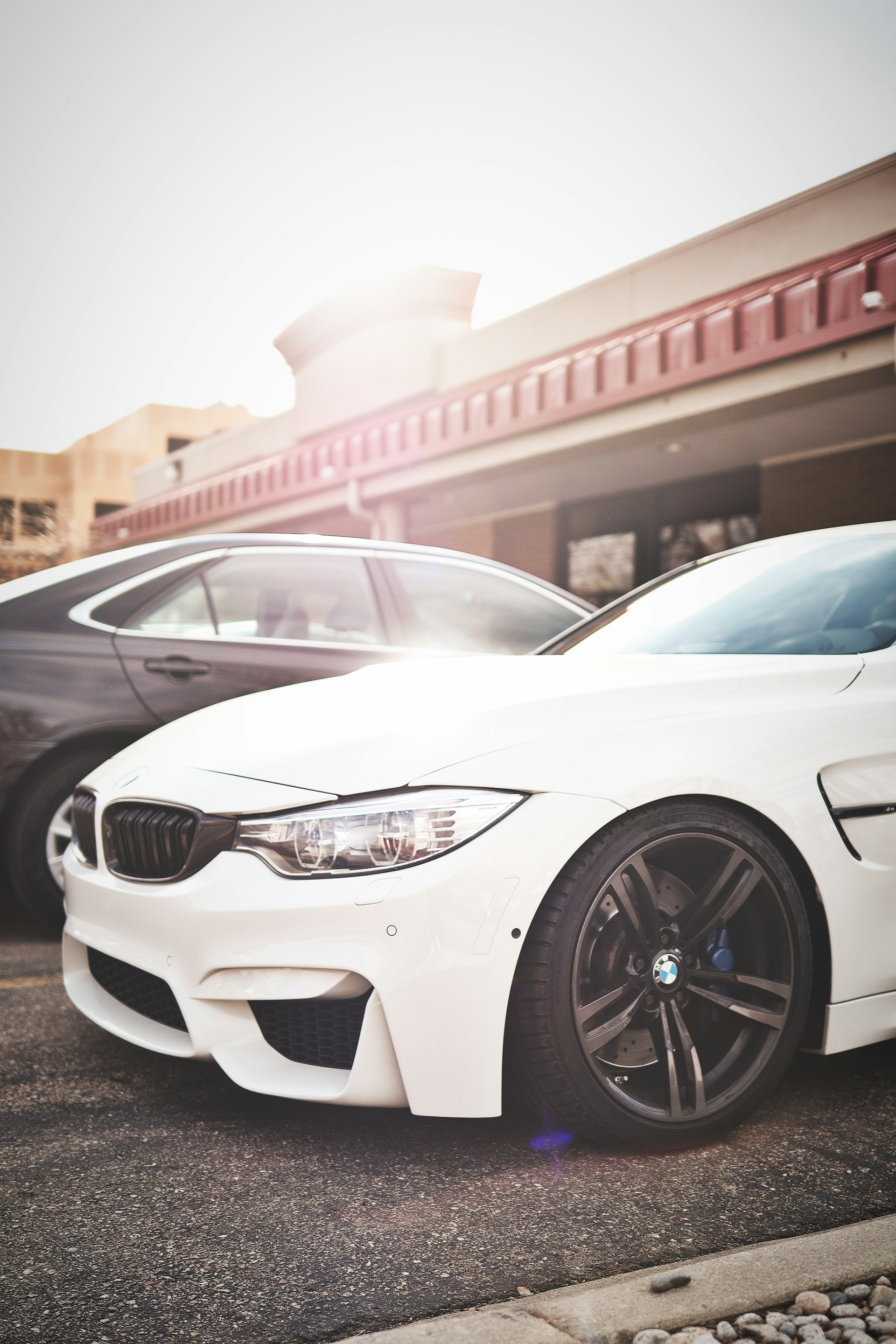 A sleek silver sedan parked on a sunlit street in Buda, Texas, with the Marvelous Auto dealership softly blurred in the background.