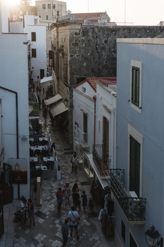 people walking on sidewalk near building during daytime in Otranto Italy