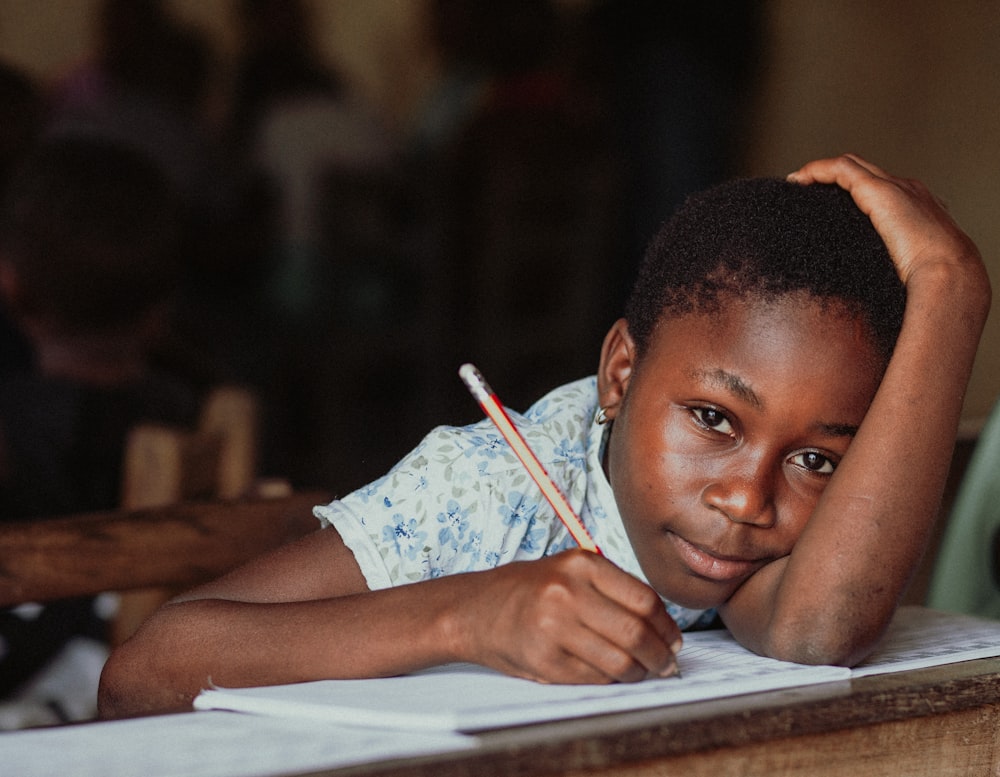 woman in white shirt holding pen writing on white paper