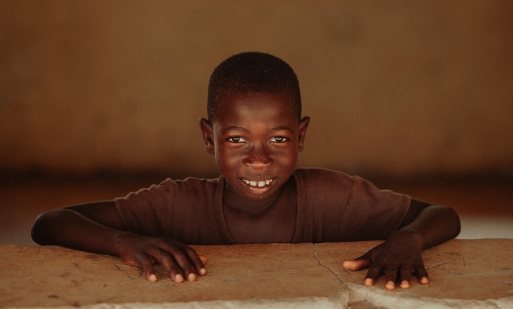 boy in brown long sleeve shirt smiling