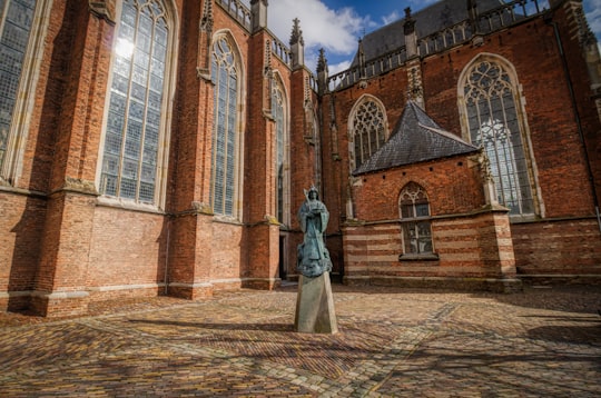 woman in white dress standing in front of brown concrete building in Zutphen Netherlands