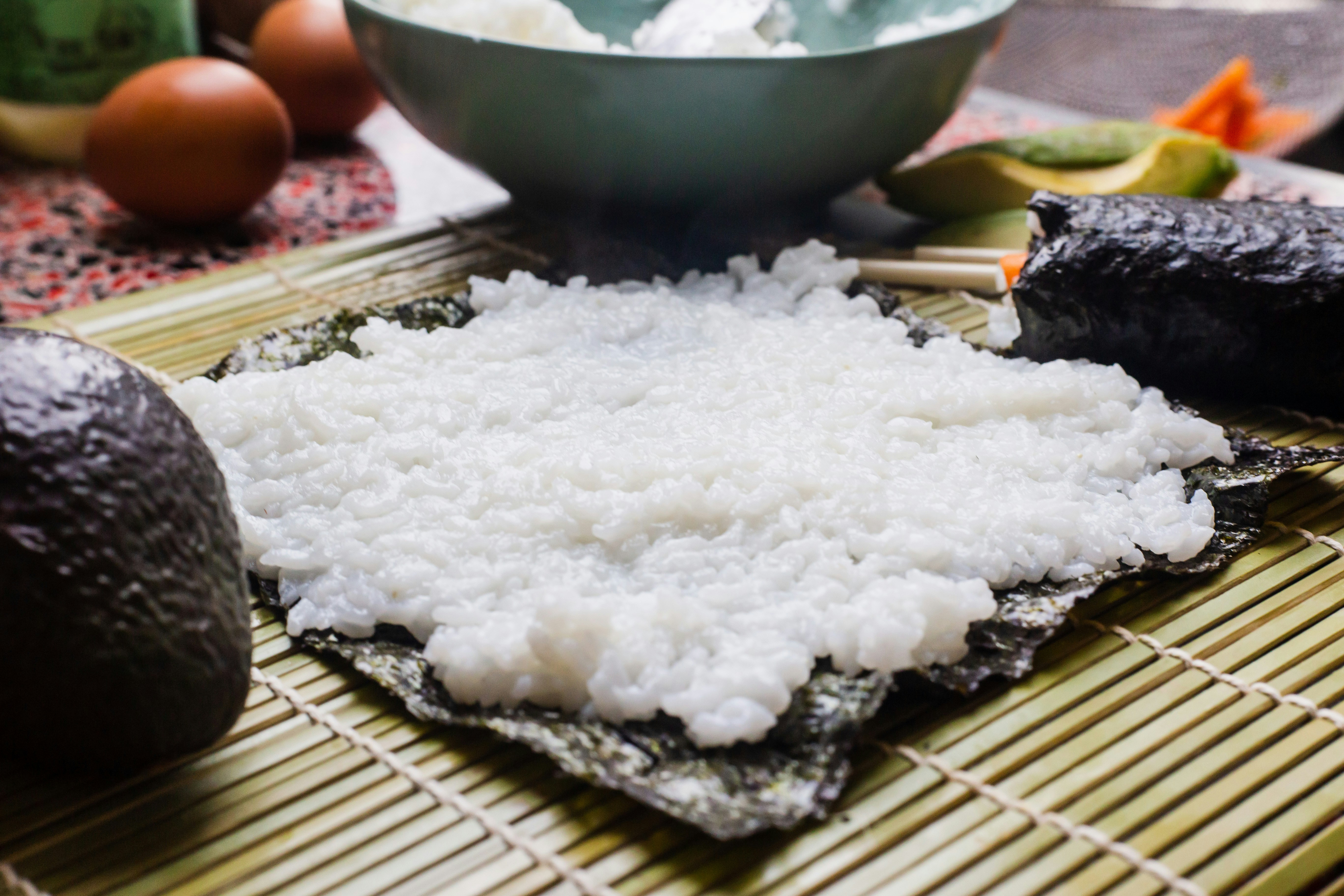 Sushi rice spread on nori on a bamboo mat