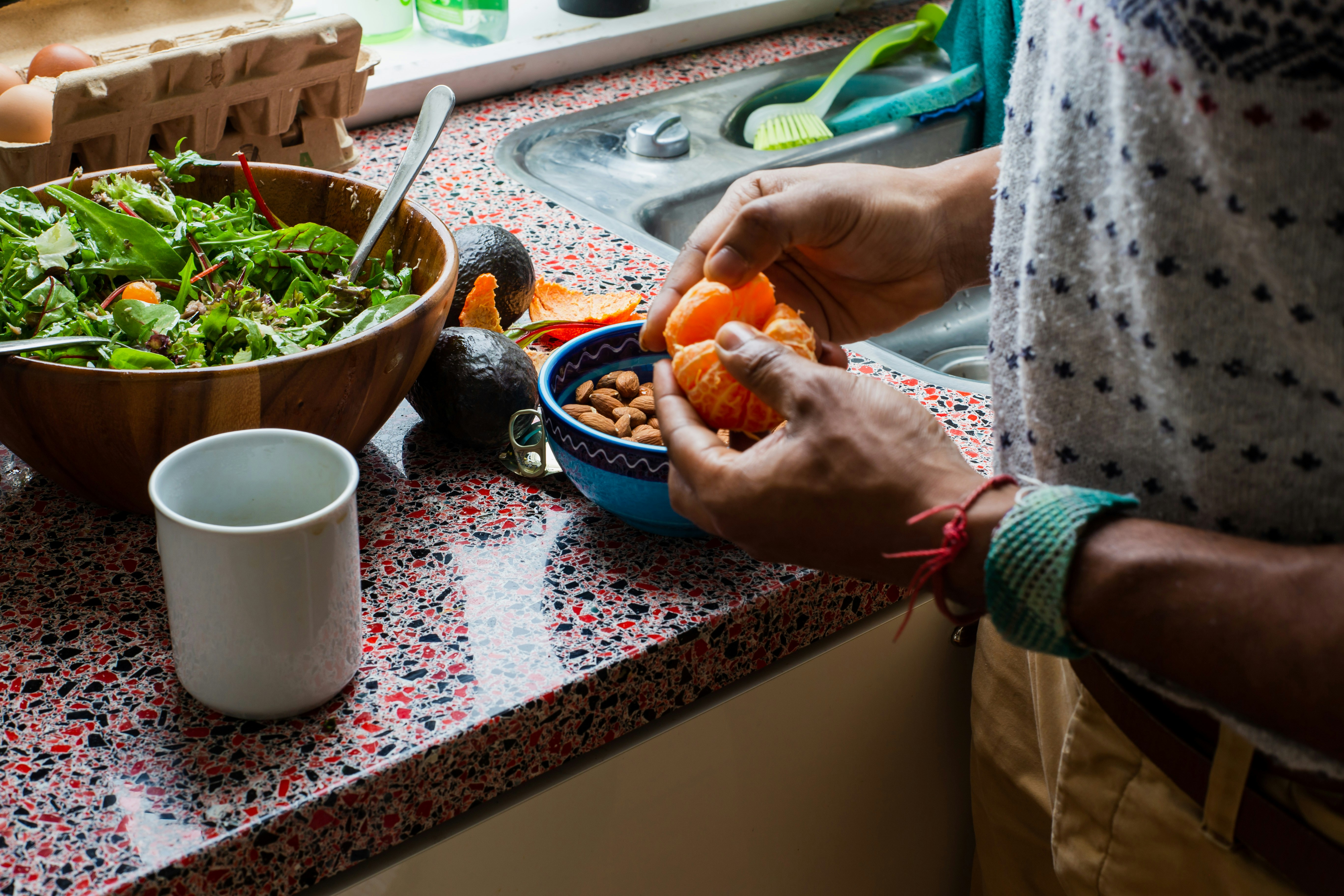 A person using the EasyHome app on a tablet to schedule meal prep time on a digital calendar in a clean kitchen.