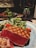A plate with seared tuna steak, showcasing a medium rare interior with grill marks on the surface. It is accompanied by a green salad with cherry tomatoes and sprinkled sesame seeds. A glass of red wine is partially visible in the background, suggesting a dining setting.