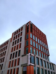 A modern prefabricated building under construction with orange and black accents.