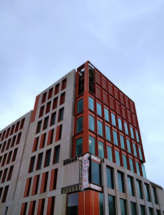 A modern prefabricated building under construction with orange and black accents.