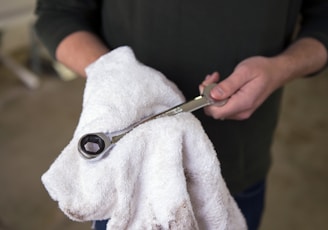 person holding silver and black scissors