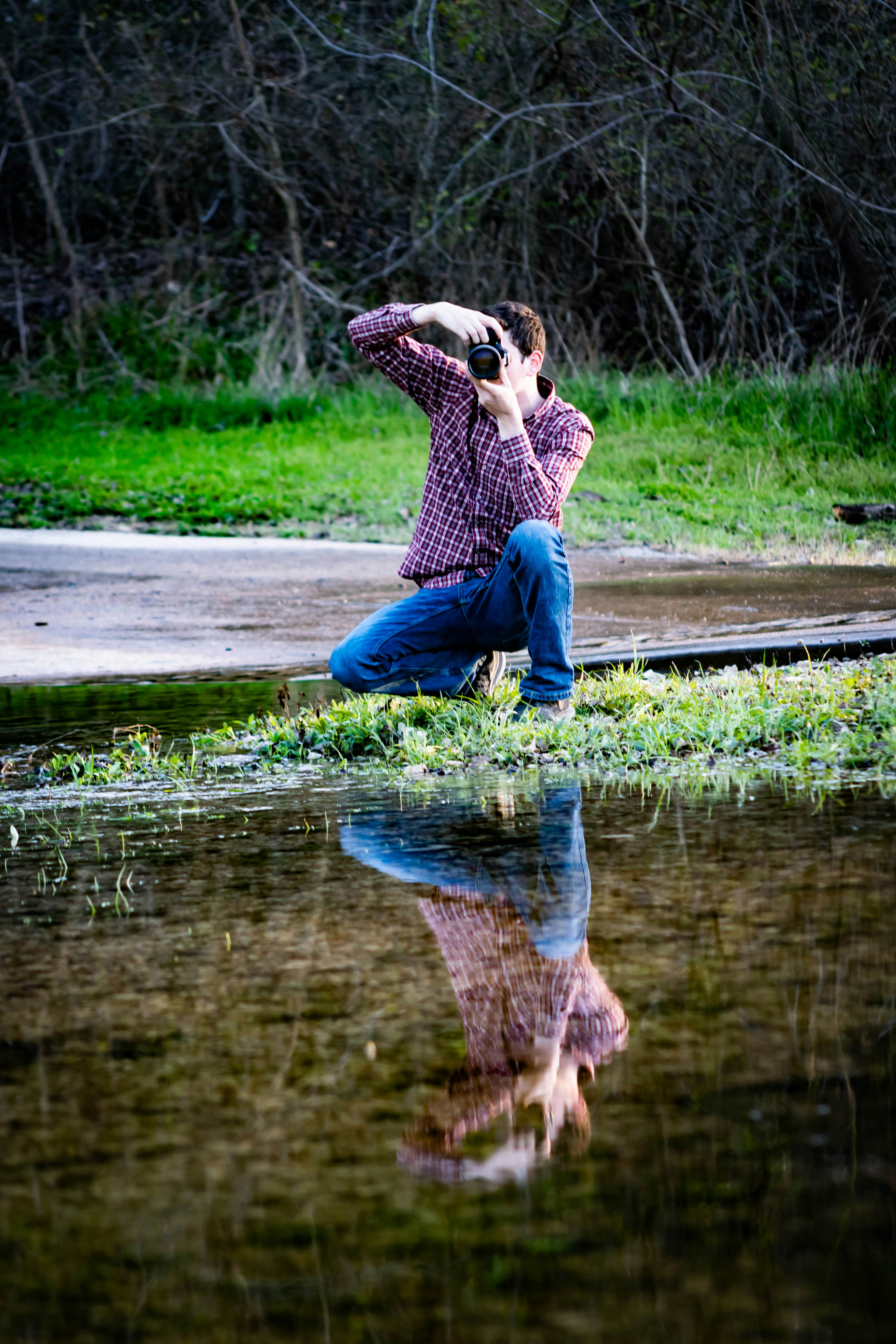 woman in blue denim jeans sitting on brown wooden dock during daytime