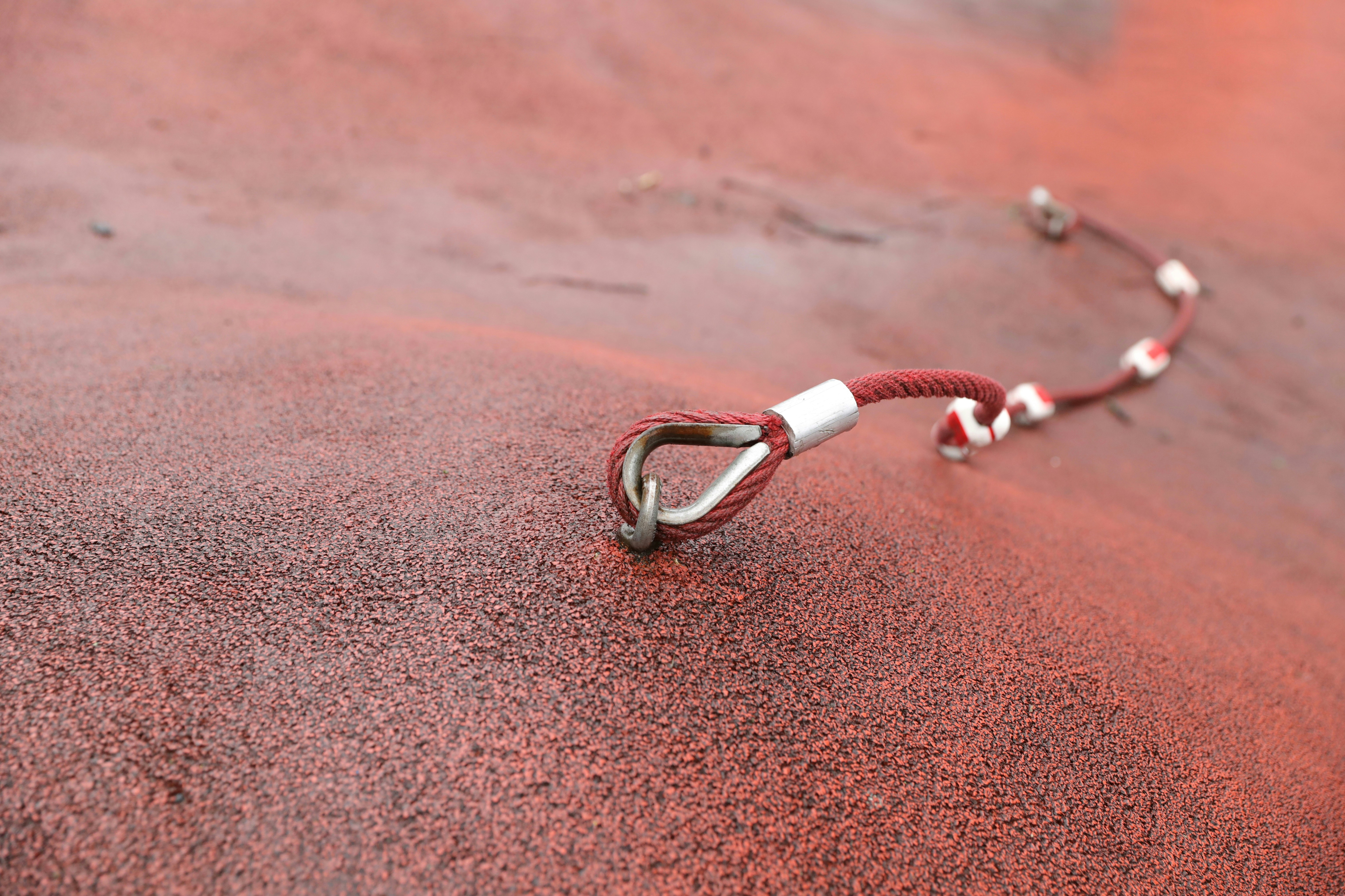 silver and red beaded bracelet on brown sand