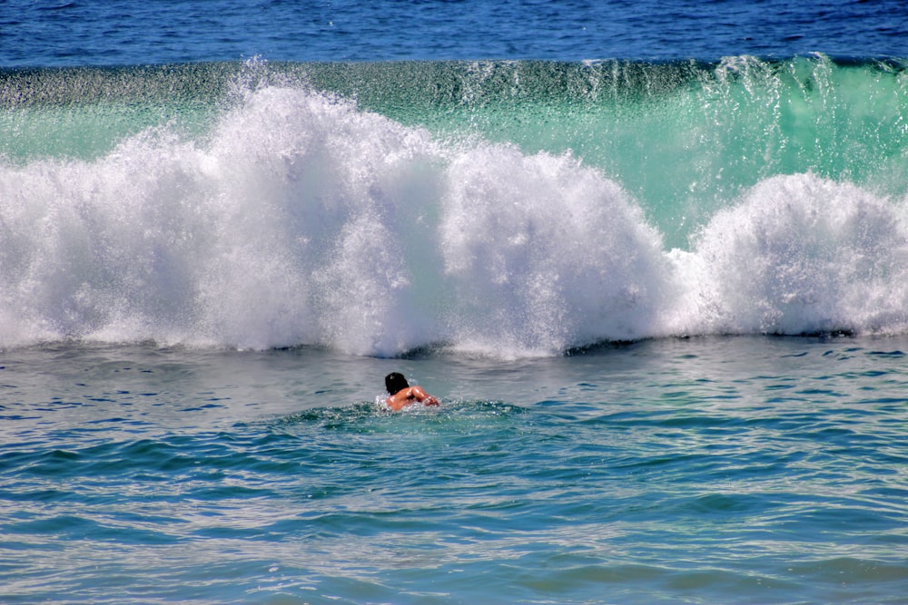 man surfing on sea waves during daytime