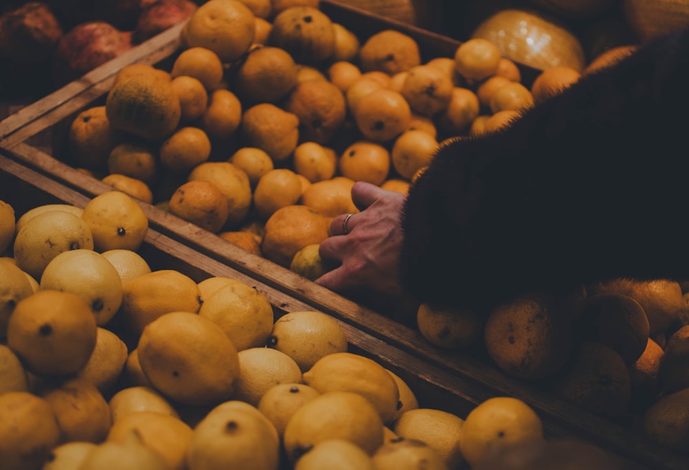 yellow round fruits on brown wooden crate