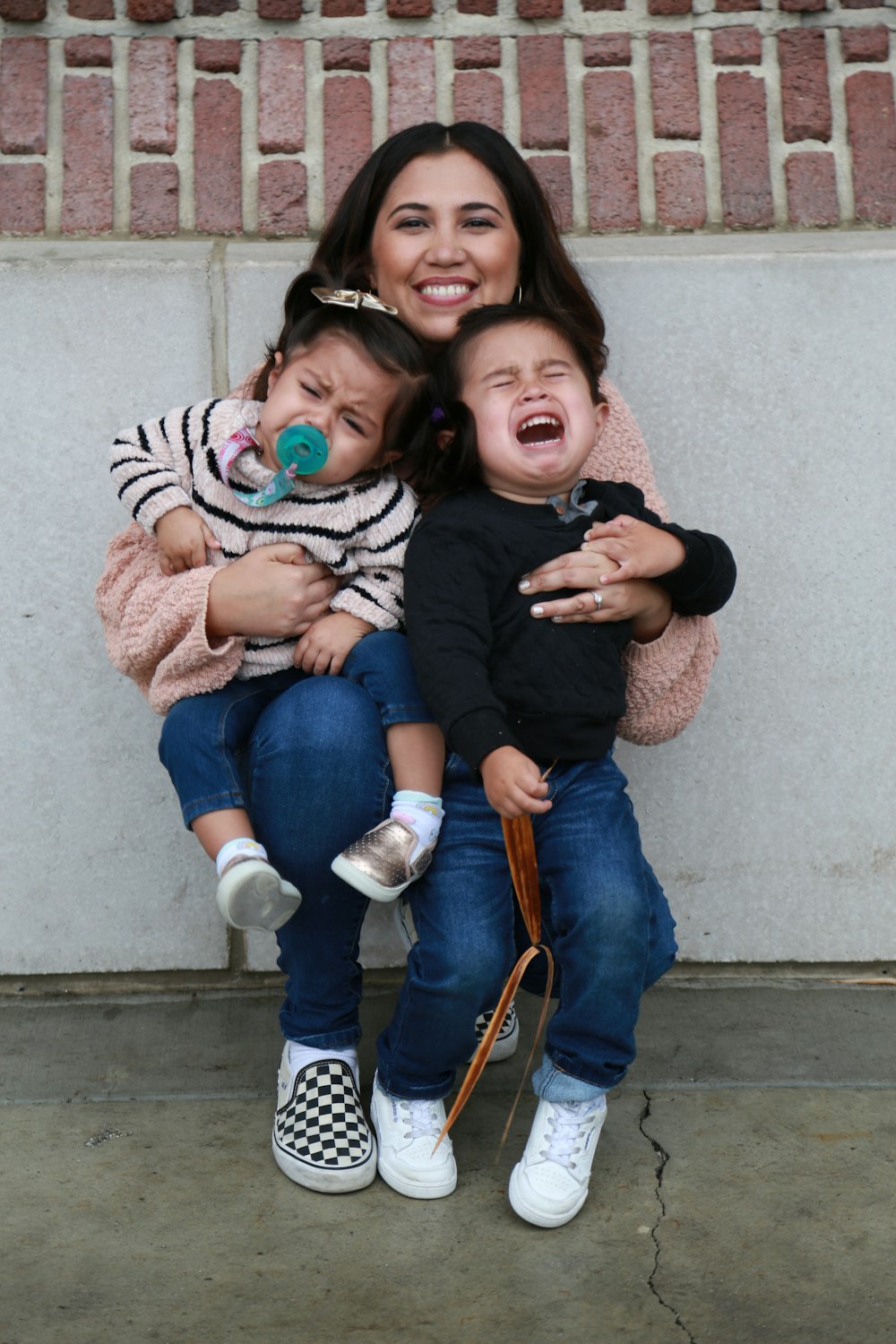 woman in black long sleeve shirt carrying girl in pink jacket