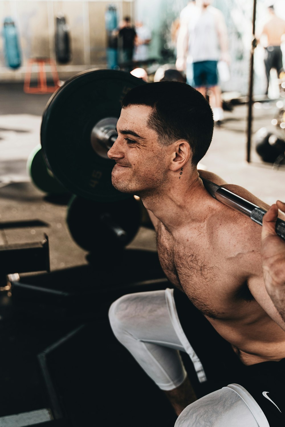 topless man in white shorts holding smartphone