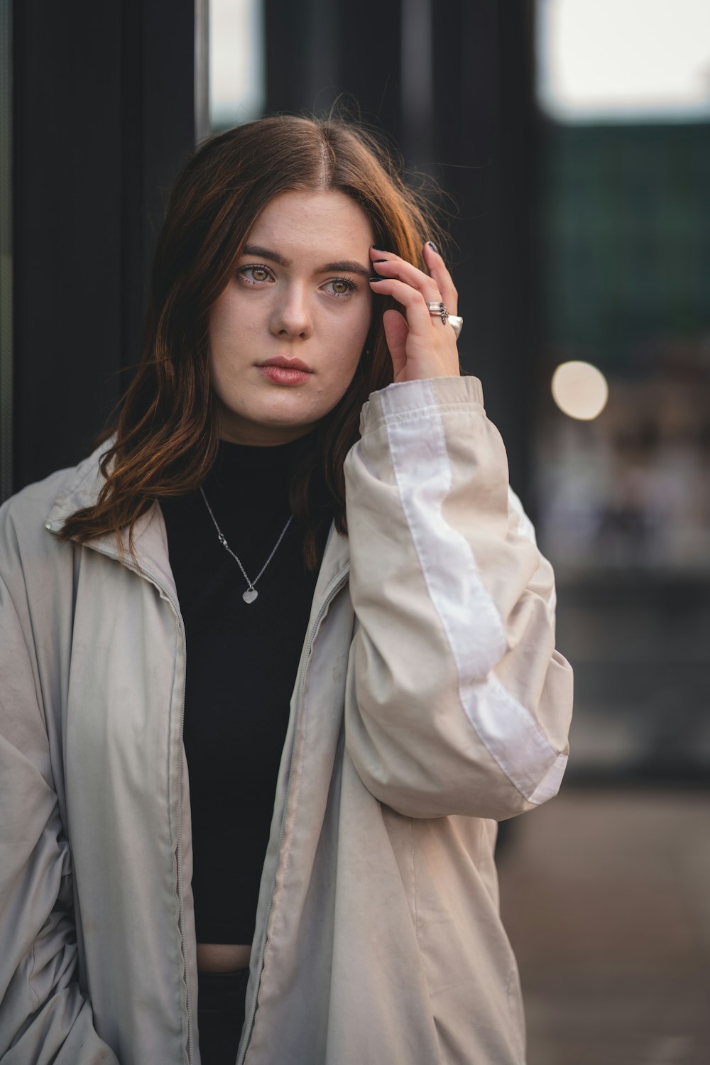 femme en manteau blanc tenant ses cheveux