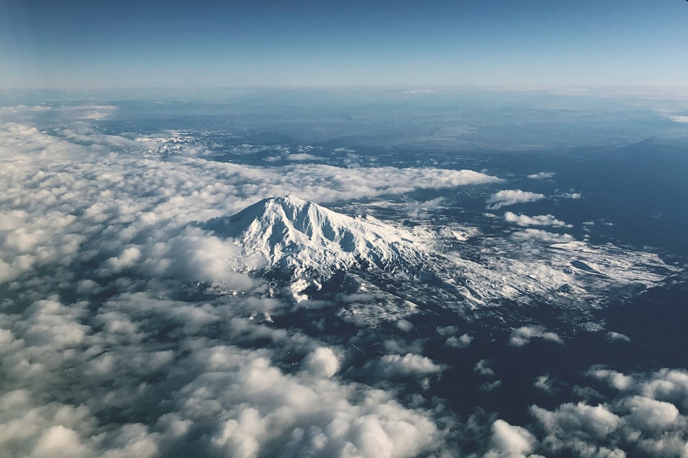 Weiße Wolken über schneebedecktem Berg