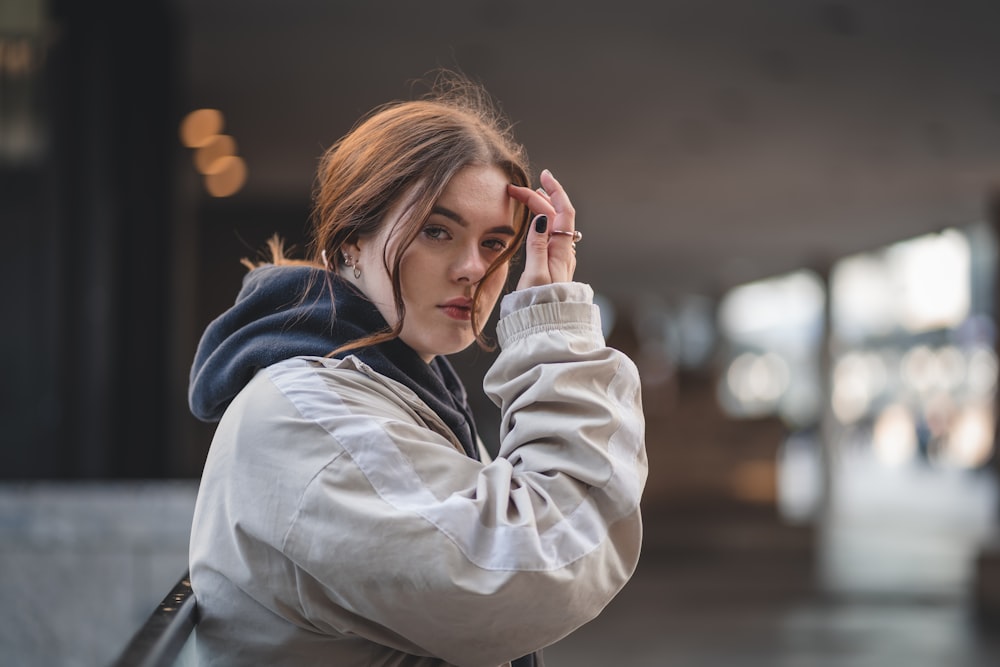 woman in gray hoodie holding white ceramic mug