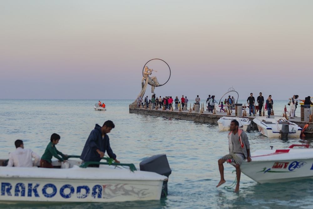 a group of people standing on a pier next to boats