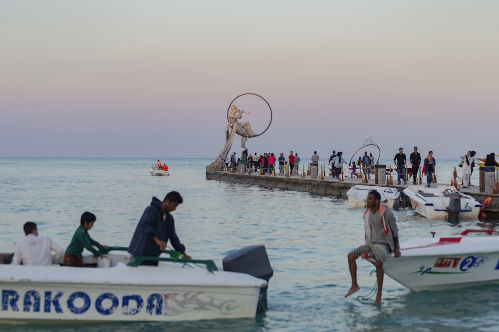 Un gruppo di persone in piedi su un molo accanto alle barche
