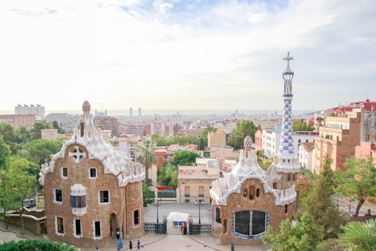 brown concrete building under white clouds during daytime in Park Güell Spain