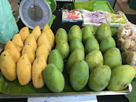 Bright yellow Sindhri mangoes neatly arranged in traditional Pakistani baskets.