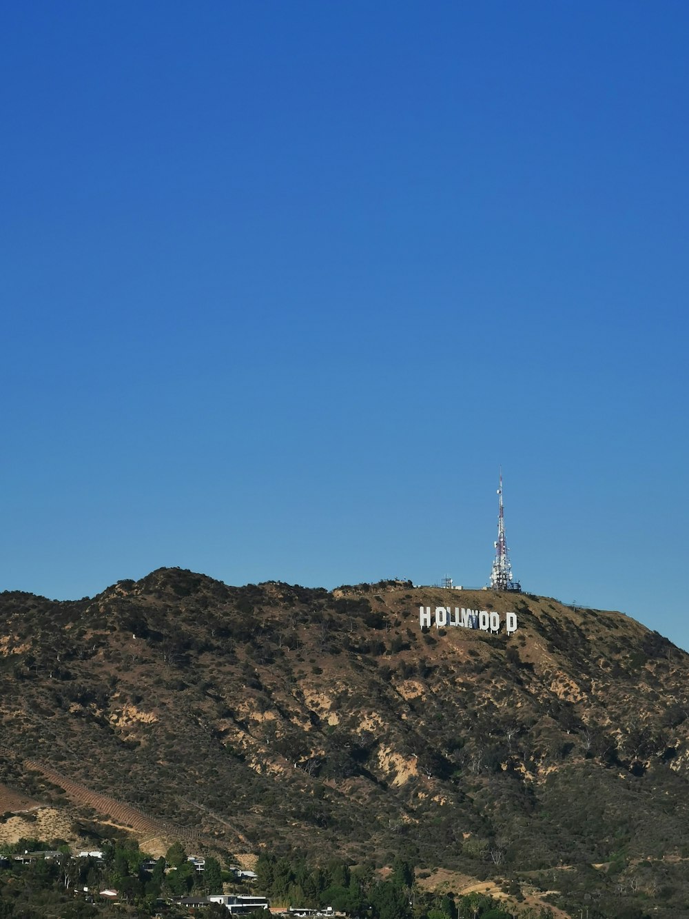 white tower on brown rock mountain under blue sky during daytime