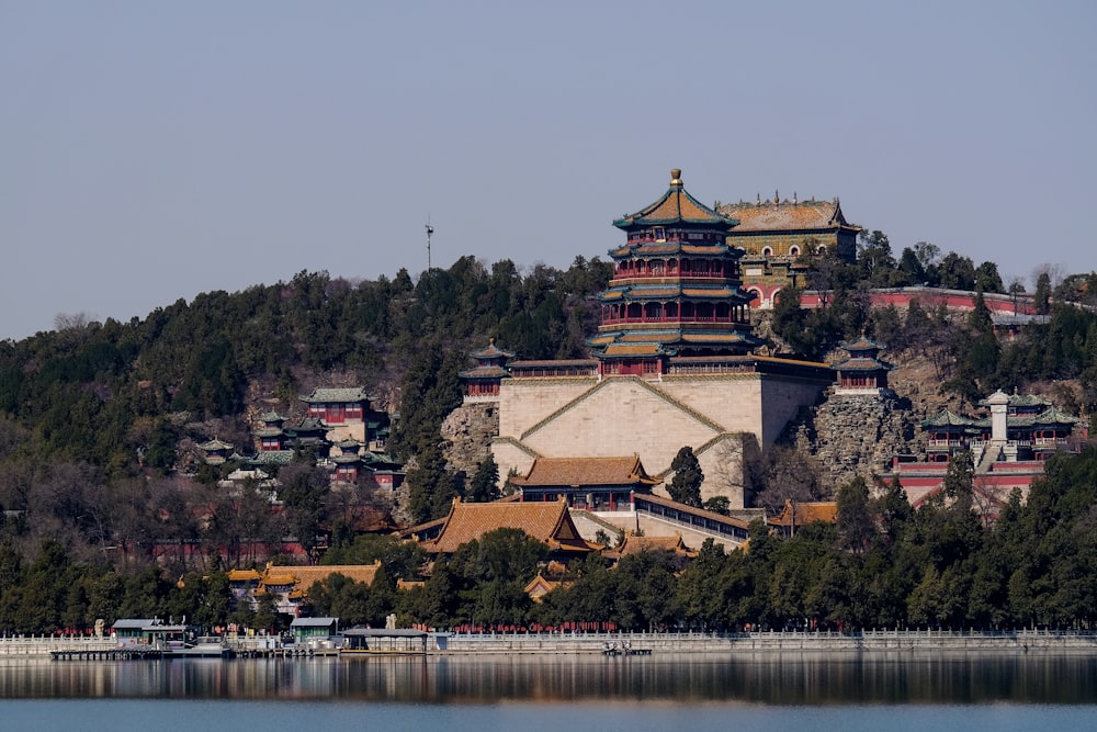 brown and white temple near body of water during daytime