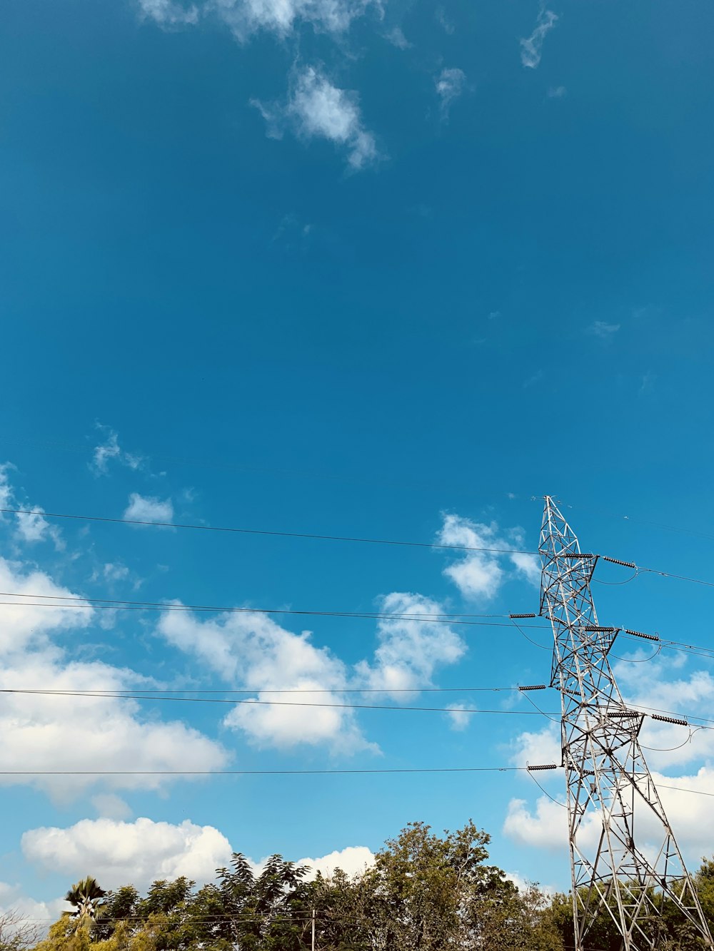 black electric post under blue sky during daytime