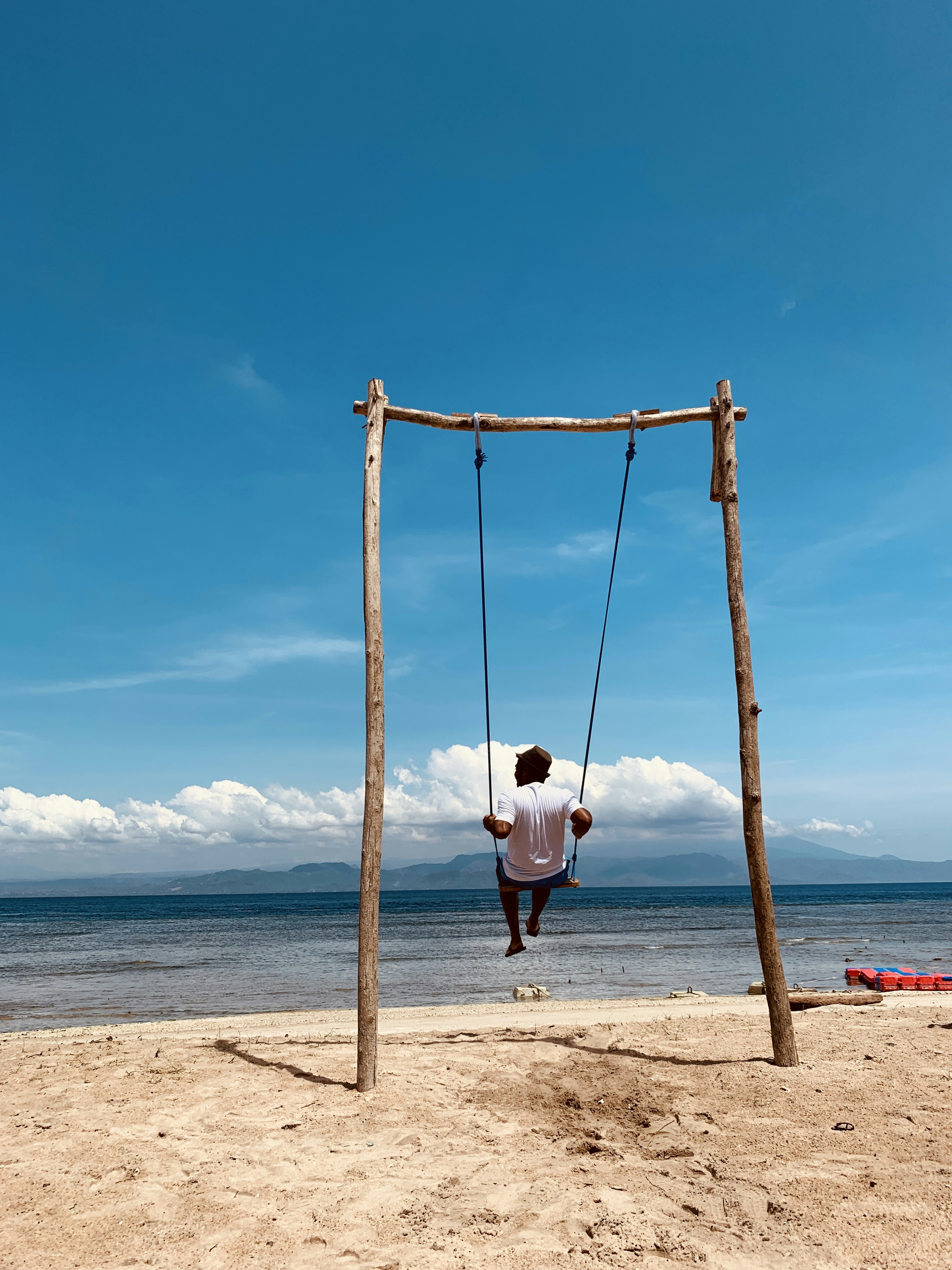 girl in white shirt sitting on swing during daytime