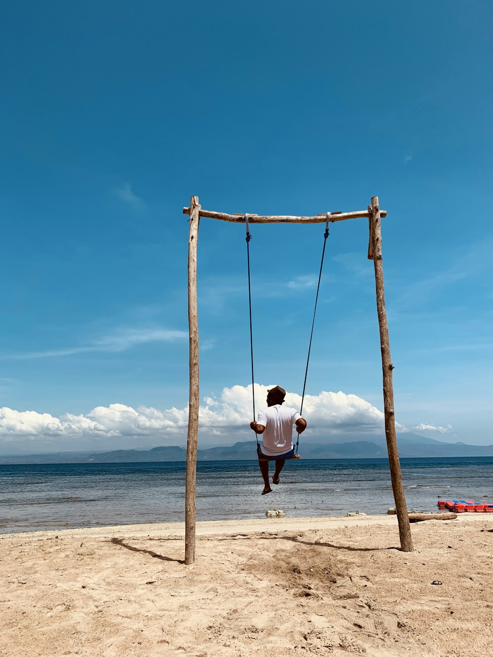 girl in white shirt sitting on swing during daytime