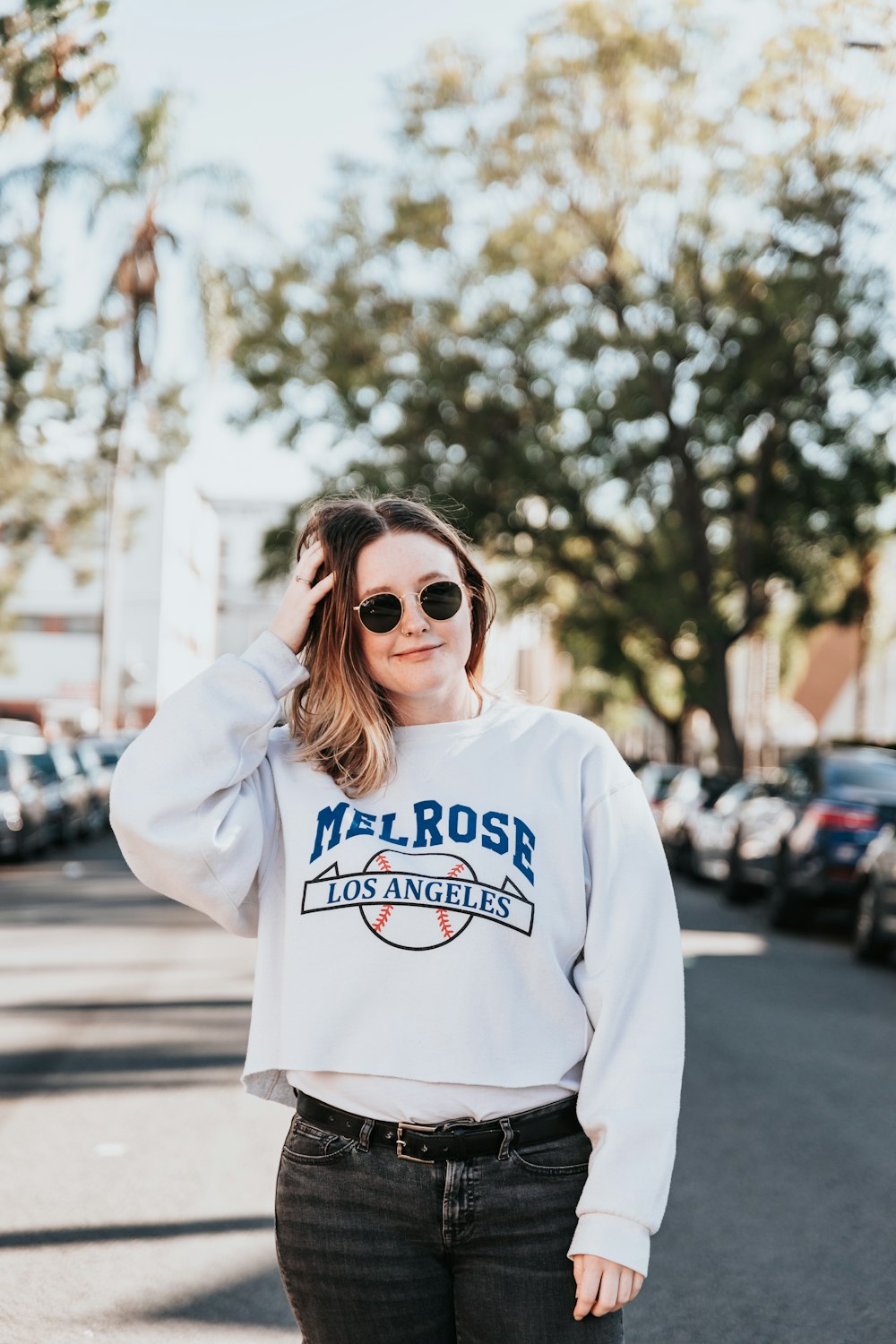 woman in white and blue pullover hoodie wearing brown sunglasses