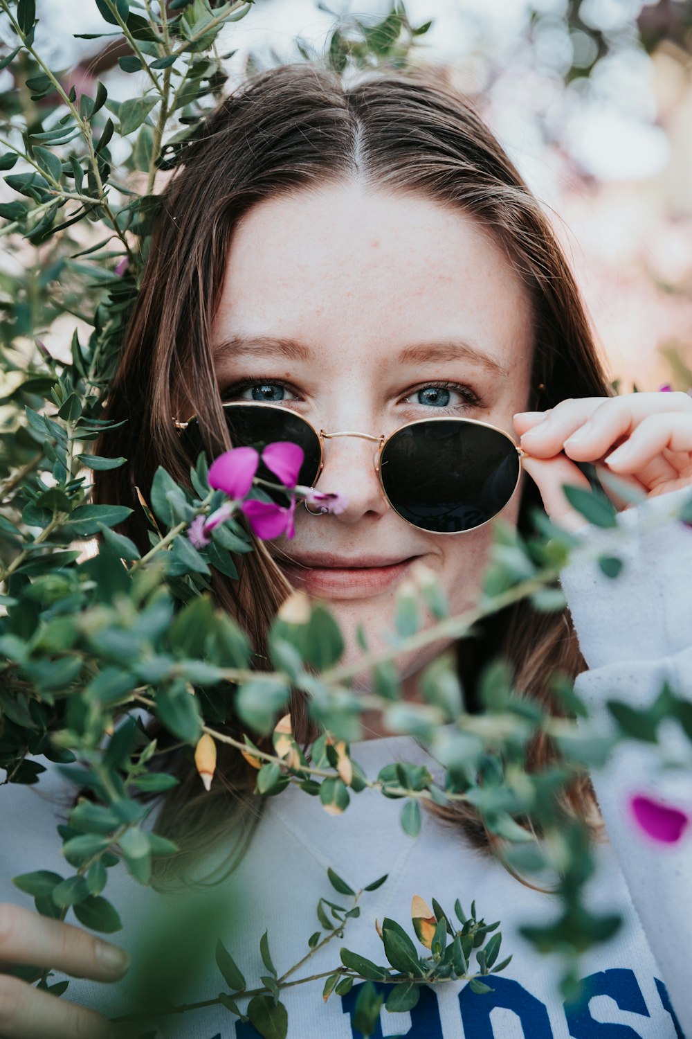 woman in black sunglasses holding green plant