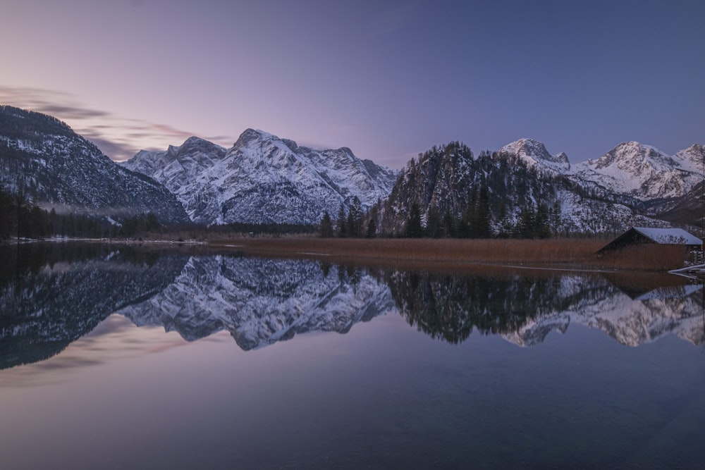 snow covered mountain near lake during daytime