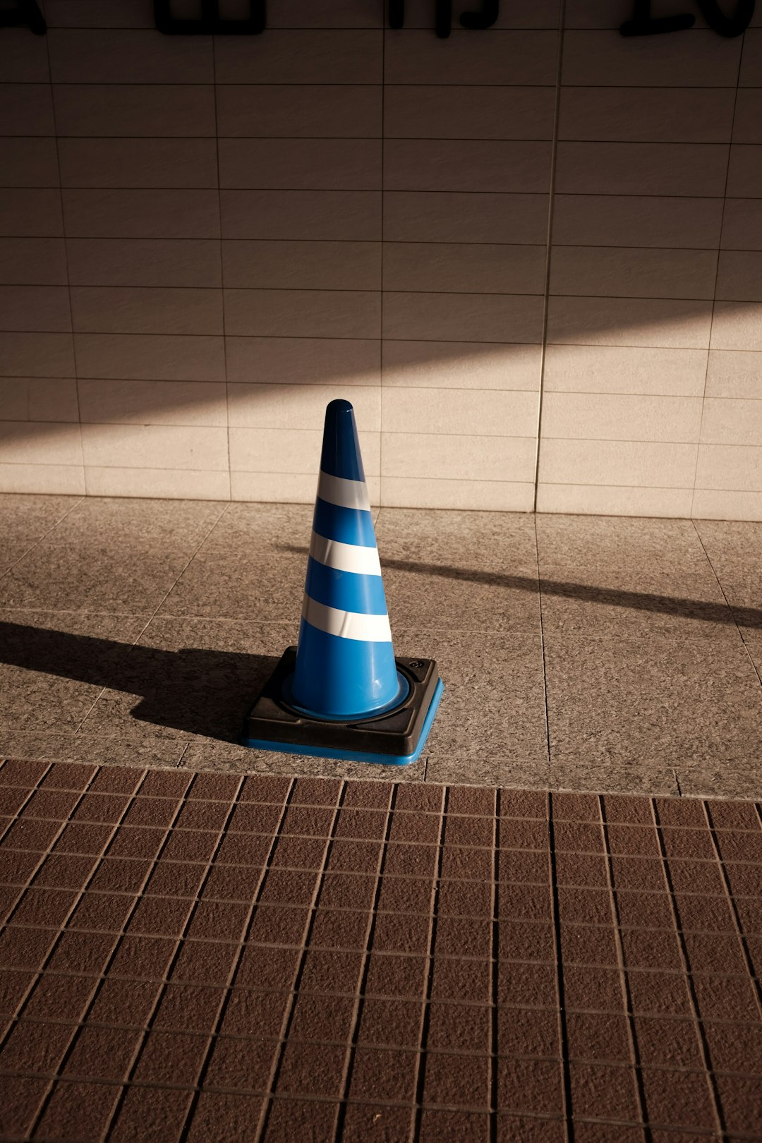 blue and white striped cone on brown floor
