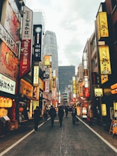 Scenic view of a bustling Japanese street with neon signs and people commuting.